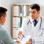 doctor showing prescription to patient at hospital